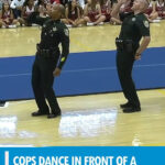 Cops dance in front of a gym-full of high schoolers