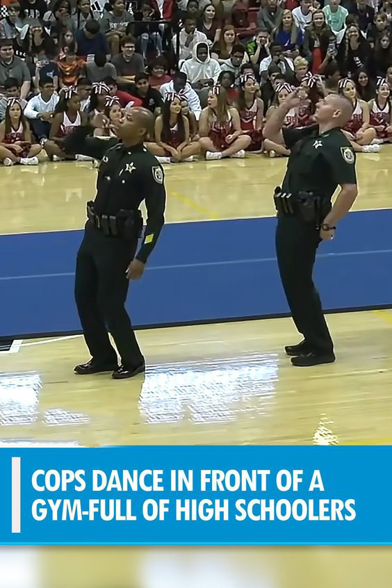 Cops dance in front of a gym-full of high schoolers